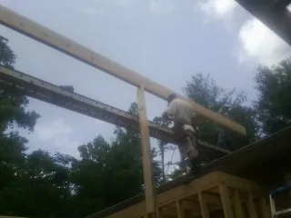 Carpenter setting a ridge beam over a new addition frame — Ice Dam Removal by Roofing Brothers in New Riegel