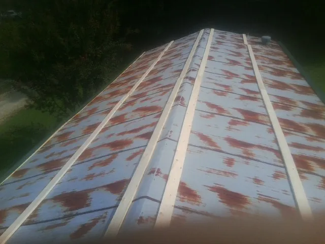 Rusted metal roof panels with new wood purlins before replacement — Storm Damage Roof Repair in New Riegel by Roofing Brothers
