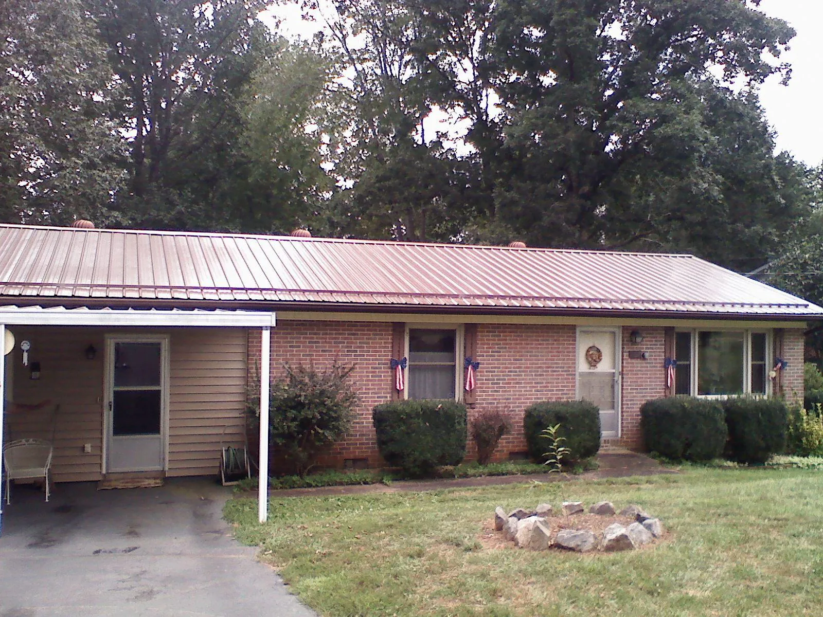 Bronze metal roof and carport on a brick ranch home — Roof Repair work by our crew in New Riegel
